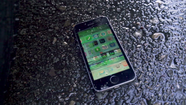 Broken, Glitching Phone on Wet Street