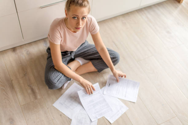 istock awesome girl sitting on the floor with documents and looking at the camera 1184139259