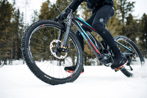 istock Midsection of mountain biker riding in snow outdoors in winter. 1184139711