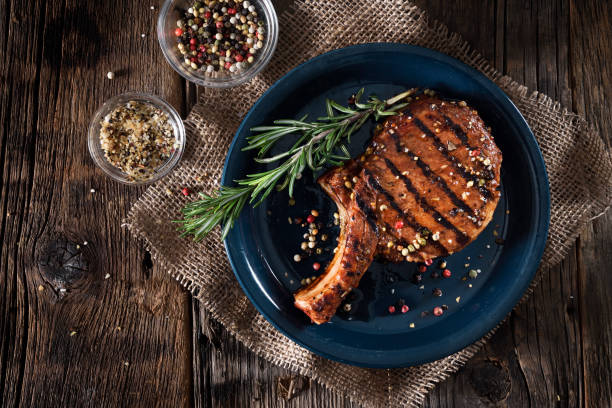 Grilled pork chop with spices Juicy grilled pork chops with spices on a dark background char grilled photos stock pictures, royalty-free photos & images