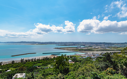 Uruma, Okinawa, Japan - April 6 2019 : The beautiful sea and Cityscape from the Katsuren Castle ruins. It was designated a UNESCO World Heritage Site in 2000 as part of one of the nine Gusuku Sites and Related Properties of the Kingdom of Ryukyu.