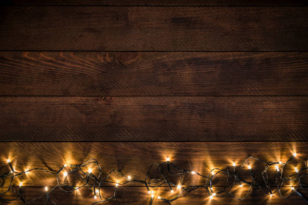 istock Empty rustic wooden table with christmas lights border stock photo 1184143845