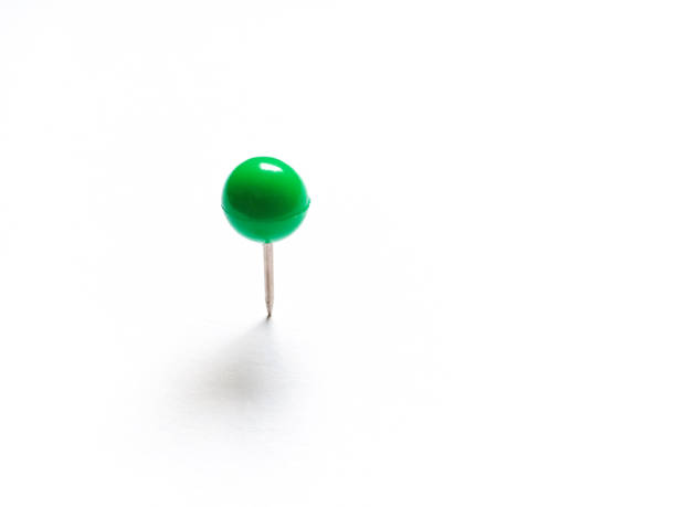 Assorted colored pushpins, stabbed in black paper