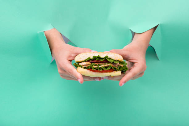 istock Sandwich in the hand on the neo mint background. Hand made. 1184145336