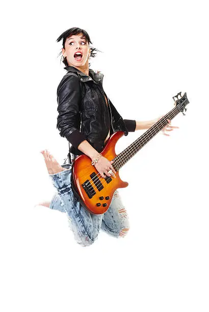 Photo of Beautiful rock-n-roll girl jumping with guitar isolated