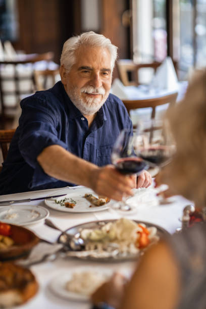 istock Senior Friends Toasting In Restaurant 1184152336