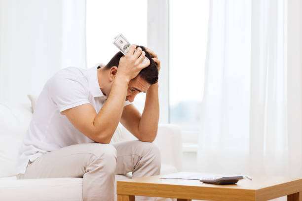istock man with money and calculator at home 1184153550