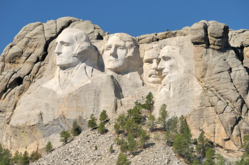 Mount Rushmore National Monument, president bust sculptures carved into a mountain in the Black Hills of South Dakota, USA as a memorial for George Washington, Thomas Jefferson, Theodore Roosevelt, and Abraham Lincoln. Designed to be used for page layout as the bottom frame border, with copy space above.