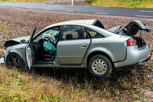 Avesta, Sweden, October 17, 2019\nSilver colored car wreck standing in a ditch by a road on the Swedish countryside. Totally wrecked with both air bags triggered
