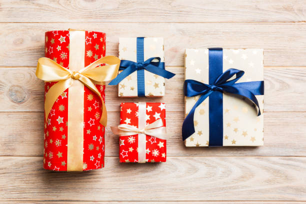 istock Beautiful gift box with a colored bow on the orange wooden table. Top view with copy space for you design. Christmas concept 1184161816