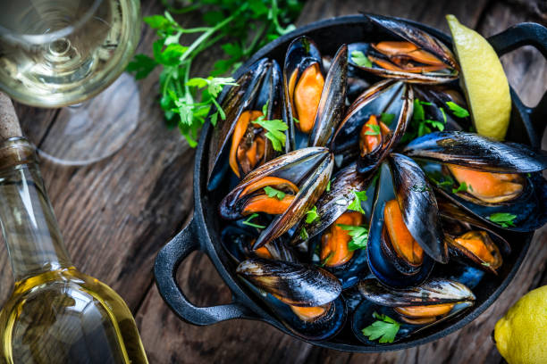 istock Steamed mussels and white wine on rustic wooden table 1184169376