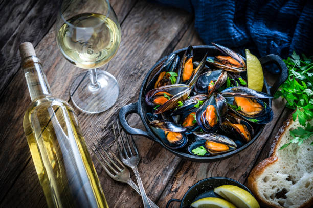 istock Steamed mussels and white wine on rustic wooden table 1184169502