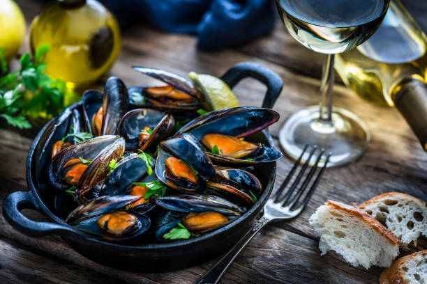 istock Steamed mussels and white wine on rustic wooden table 1184169516