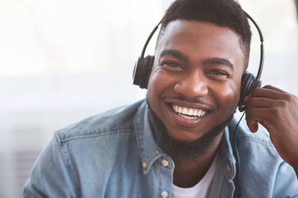 istock Portrait of smiling black call center operator in headset 1184169771