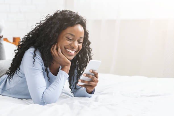彼女のボーイフレンドからのメッセージを読んで愛の黒人の女の子 - video sharing ストックフォトと画像