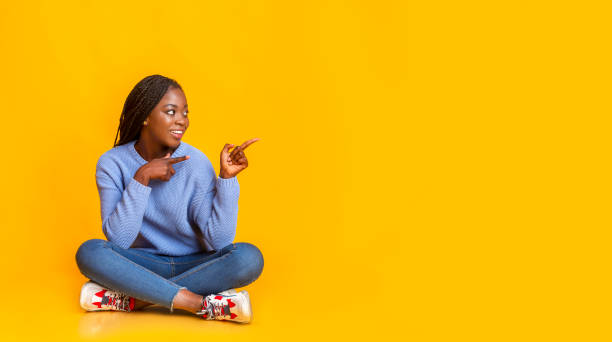 istock Happy afro girl in blue pointing at copy space 1184170519