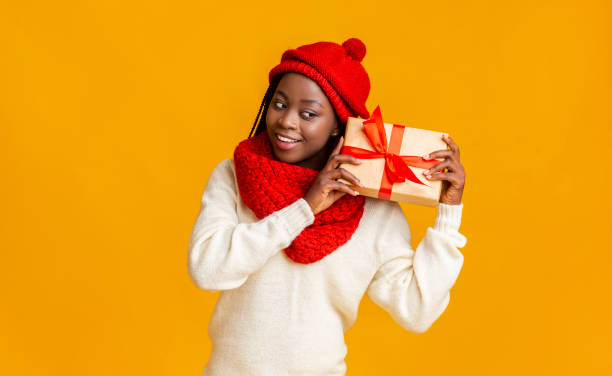 istock Interested black girl in red hat checking on her gift 1184170566