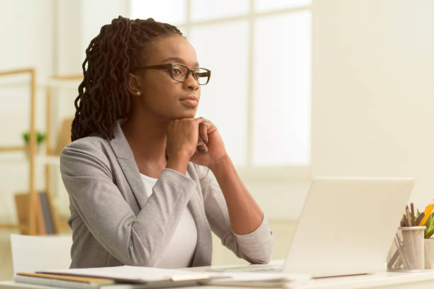istock Serious Afro Lady Sitting At Laptop Looking Aside In Office 1184170718