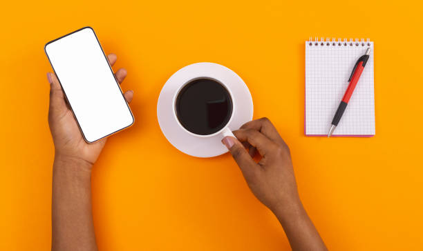 istock Woman's hands holding smartphone with blank screen and coffee cup 1184171242