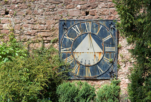 old sundial on a brick wall sunny scenery including a old weathered sundial in Southern Germany color image roman numeral rusty time stock pictures, royalty-free photos & images