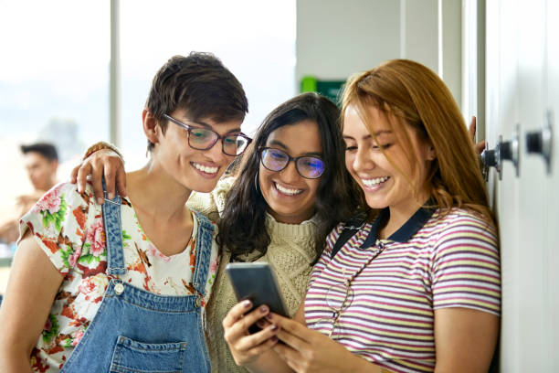 istock Female friends looking in cellphone at university 1184176734