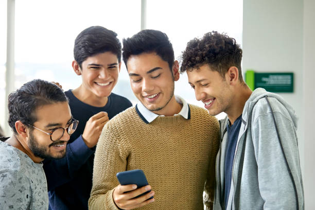 istock Male friends looking in cellphone at university 1184176811