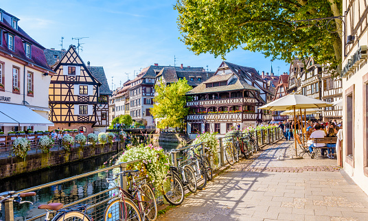 Strasbourg, France - September 14, 2019: Late afternoon sunshine on the Benjamin Zix square in the Petite France quarter, along the canal lined with half-timbered houses, very popular with tourists.