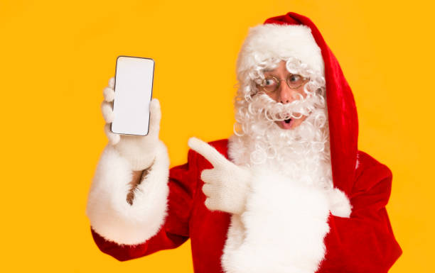 istock Santa Claus showing on cellphone with blank screen on orange 1184180942