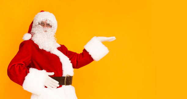 istock Santa Claus holding hand for your text over orange background 1184182092