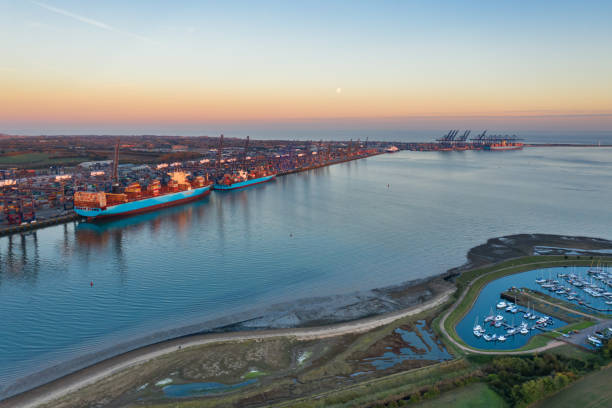 Felixstowe Container Port Sunset and moonrise over Felixstowe container port shot from a drone over Shotley Gate, Suffolk, United Kingdom estuary photos stock pictures, royalty-free photos & images