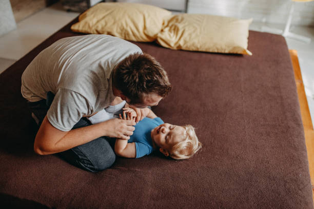 istock Father playing in bed with his little baby boy 1184183581