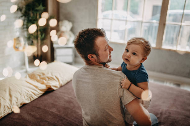 istock Happy father with his son playing at home on the bed 1184184034