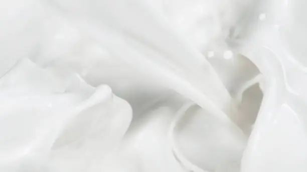 Macro shot of pouring cream in detail. Close-up of fresh milk or cream.