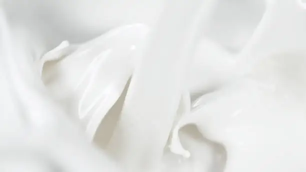 Macro shot of pouring cream in detail. Close-up of fresh milk or cream.