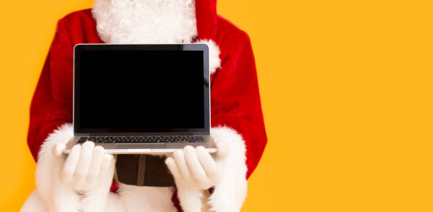 Santa Claus showing modern laptop with black blank screen
