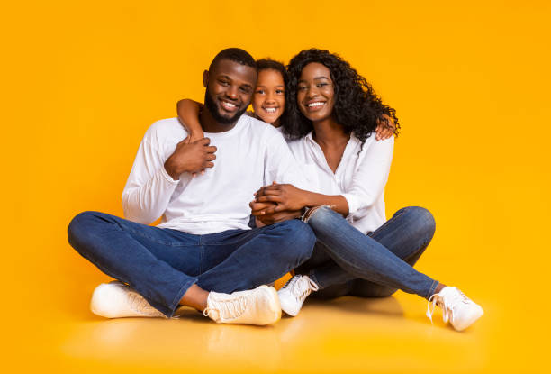 istock Happy black family embracing while sitting on floor together 1184189569