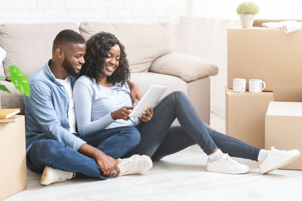 istock Black woman showing her man ideas for interior on tablet 1184190147