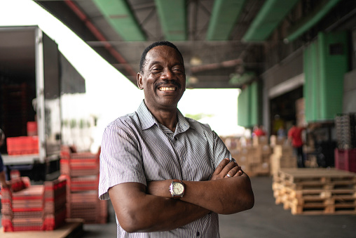 African mature man owner portrait at warehouse