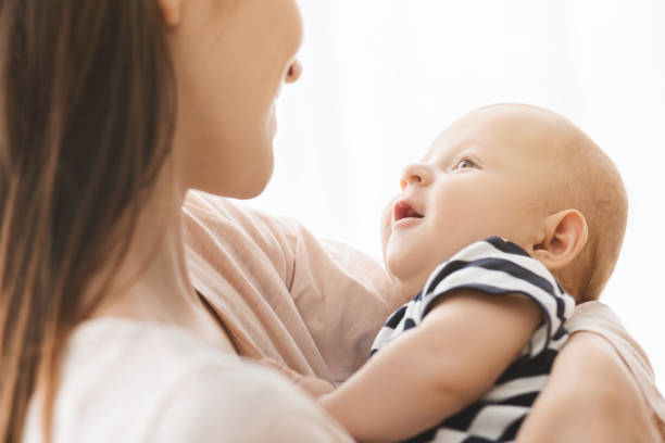 istock Cute newborn baby smiling while lying on mother's hands 1184191340