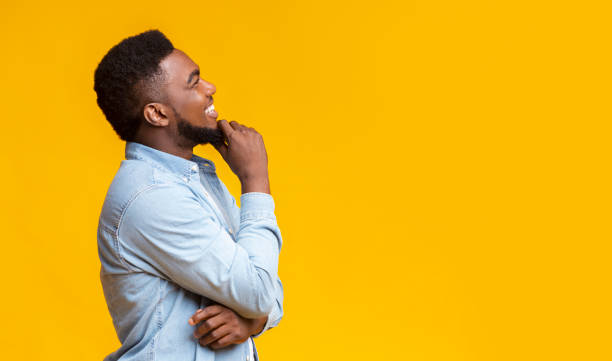 istock Profile portrait of smiling black guy touching his beard 1184191583
