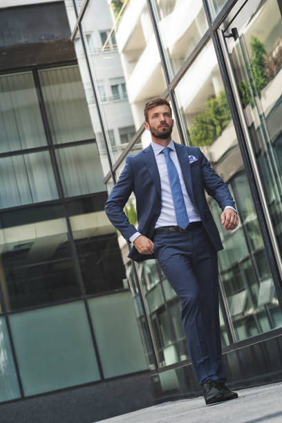 istock Handsome classy man in suit walks down the city street 1184192637