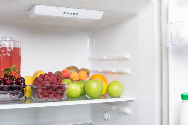 istock fruits, berries and a drink lie inside a white open refrigerator 1184194215