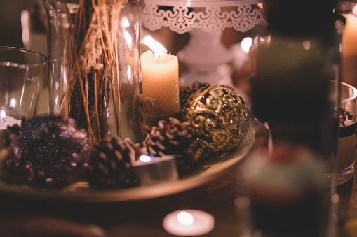 christmas dinner table decoration with candle lights and christmas ornament on wooden table