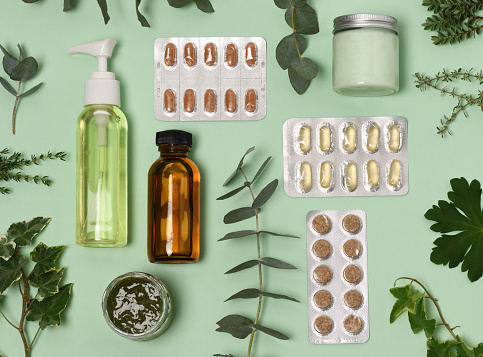 arrangement of organic pills, creams and plants