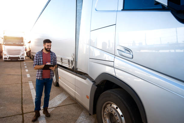 運転前にトラック車両を検査するトラック運転手。輸送サービス。 - truck semi truck blue truck driver ストックフォトと画像