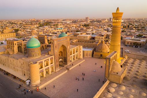 Aerial view of the center of Bukhara around the Kalyan minaret (nearly 46 m hight and build in the early 12th century!) the Kaylan mosque (right, 16th century) and the Mir-i Arab Madrassah (the two domes left 1535–1536). The center of Bukhara (also calloed Buchara or Buxoro) is listed as UNESCO World Heritage Site. Bukhara was one of the most important oasis and place of caravanserais at the Great Silk Road.