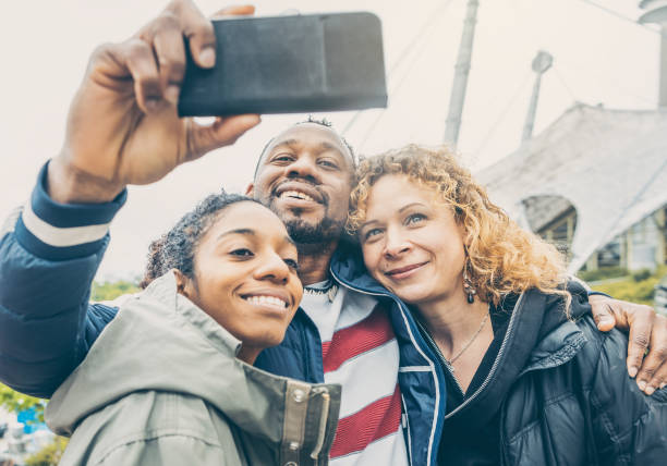 istock Three friends taking a selfie with a phone 1184201824
