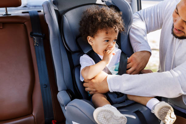 istock Young man fasten his son in a baby seat 1184202680