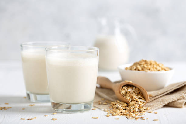Oat milk. Healthy vegan non-dairy organic drink with flakes Oat milk. Healthy vegan non-dairy organic drink with flakes alternative lifestyle stock pictures, royalty-free photos & images