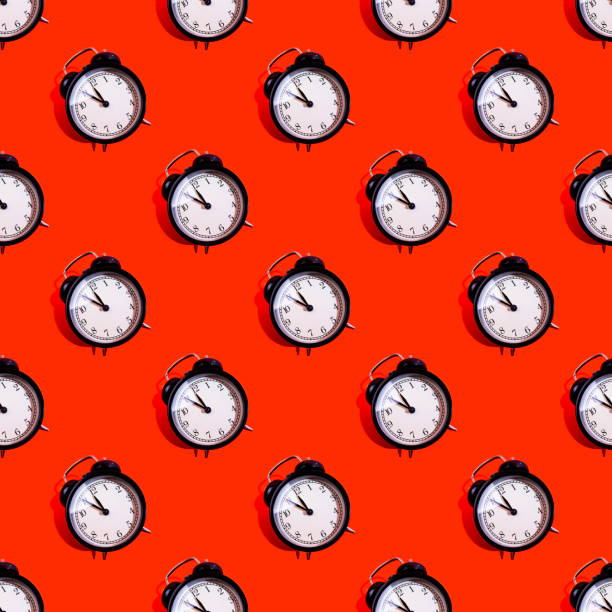 istock Many black classic style alarm clock isolated on red background 1184208520